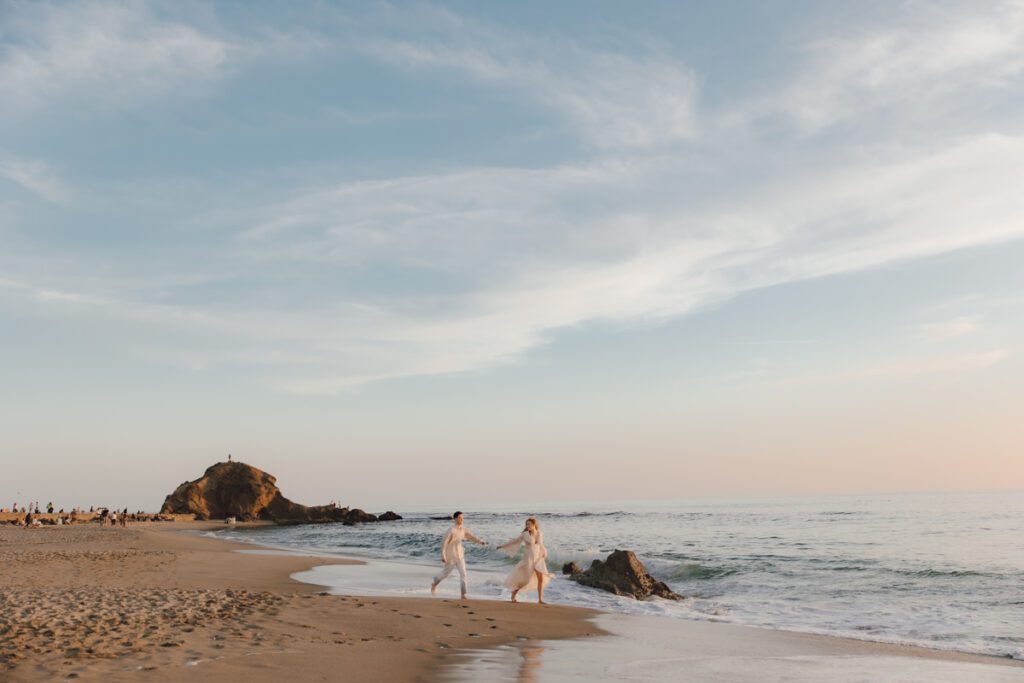 Wide shot of Laguna Beach with the ocean, cliffs, and a glowing sky