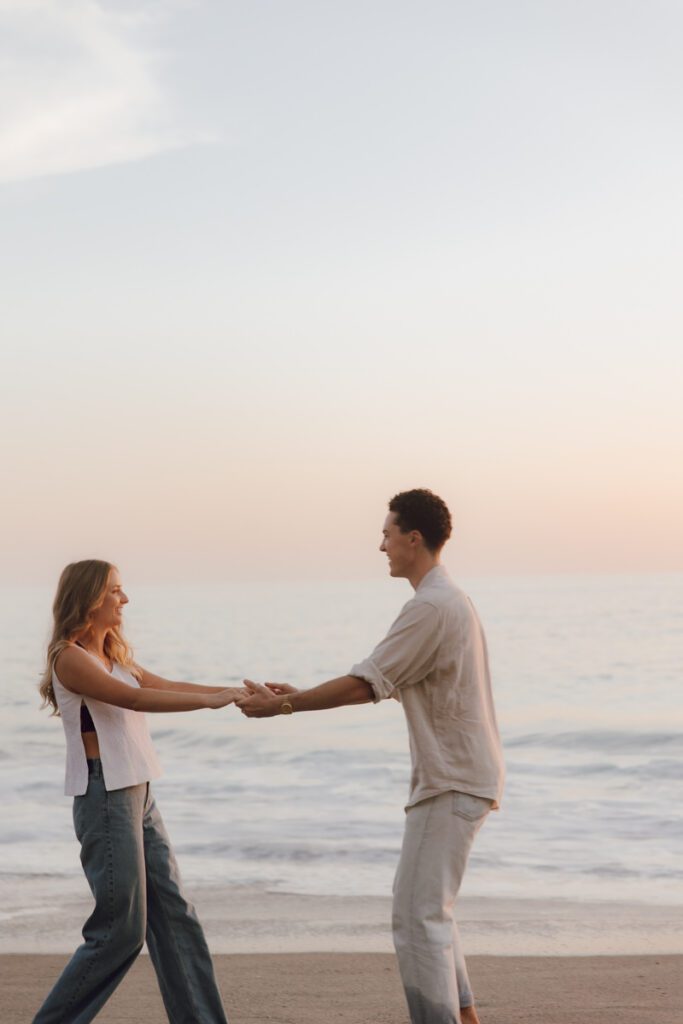 Lauren and Ben dancing on the shoreline as the sky turns golden