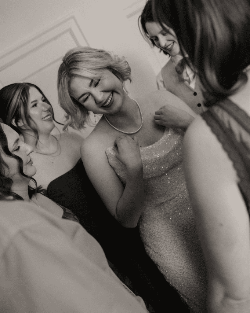 Bride laughing and smiling with her bridesmaids during their first look