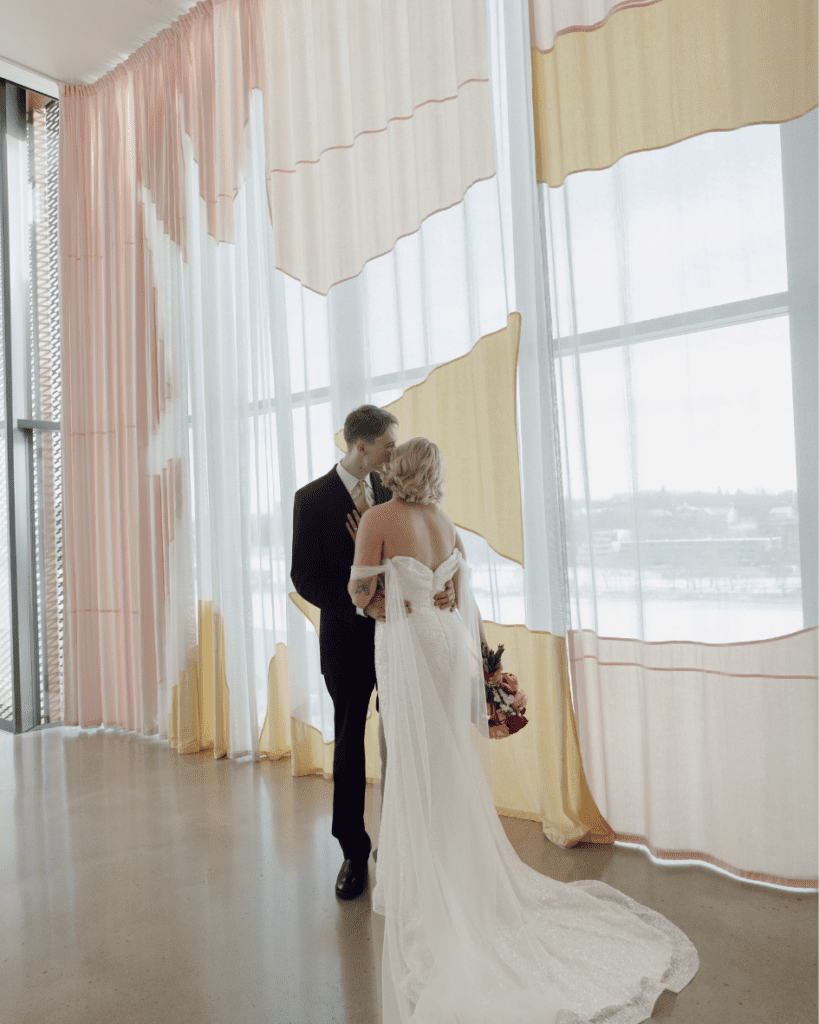 Bride and groom holding hands during emotional vow moment at the Remai Modern