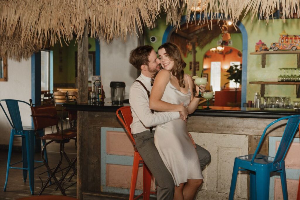 Chelsea and Michael laughing together during their engagement session at Las Palapas