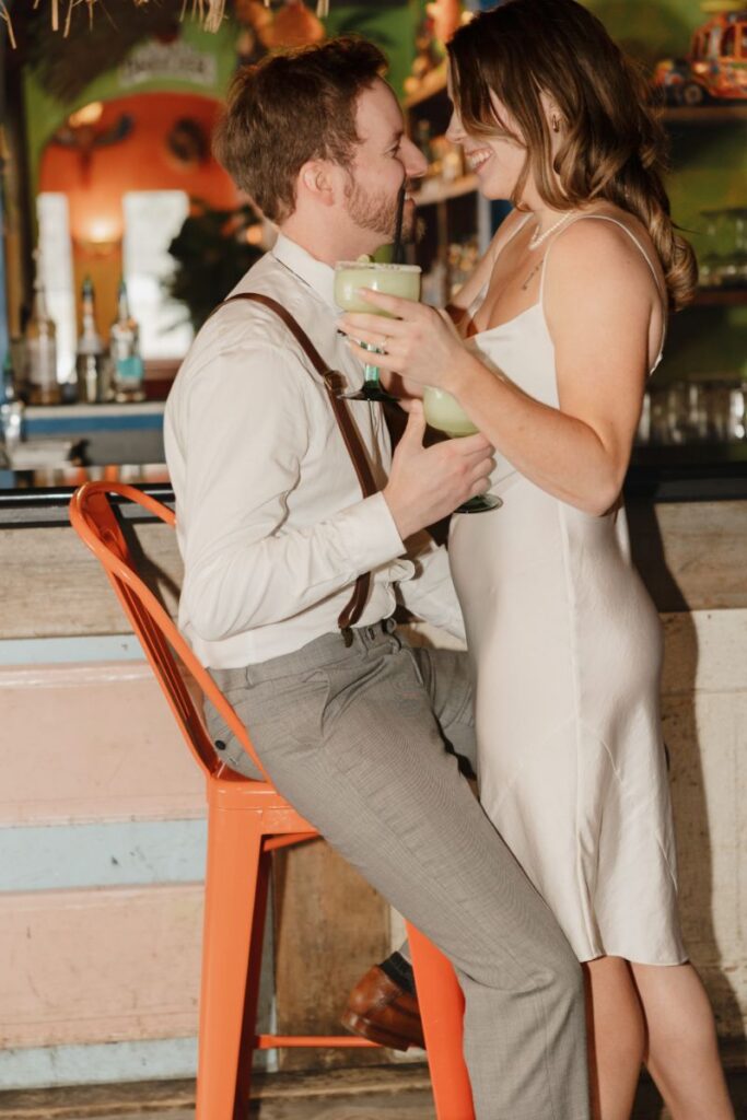 Chelsea and Michael laughing together during their engagement session at Las Palapas