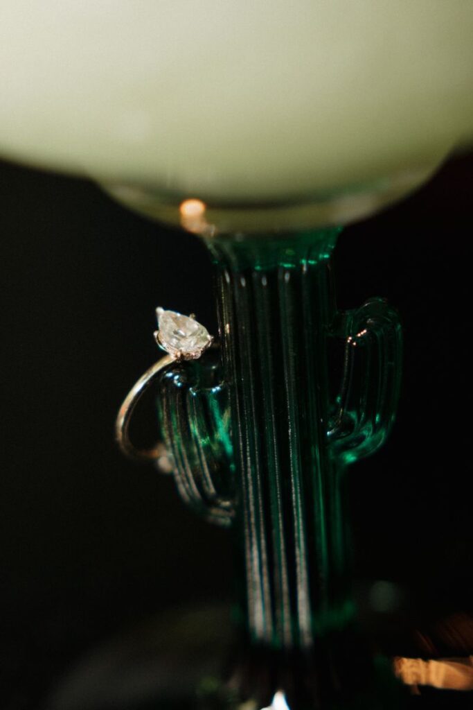 Close-up of Chelsea’s engagement ring with margarita glass in background