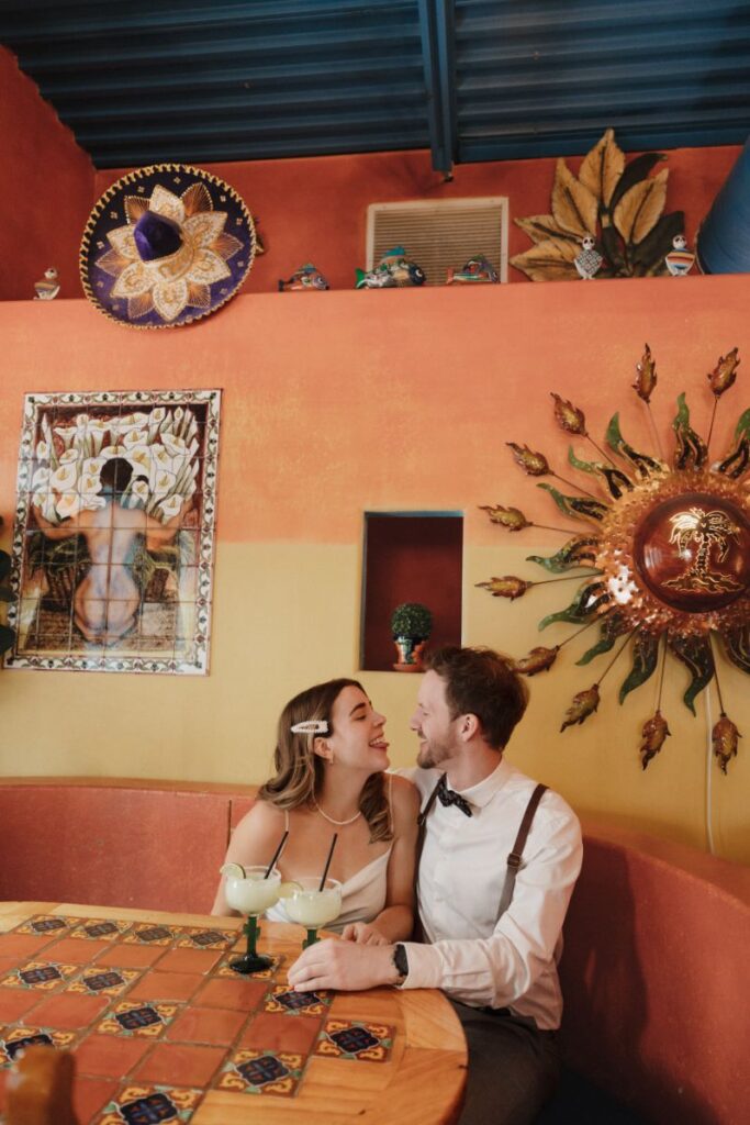 Chelsea and Michael laughing together during their engagement session at Las Palapas