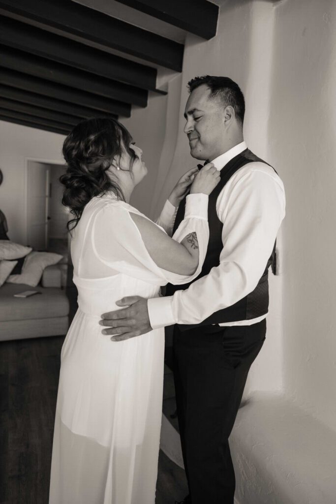 Bride and groom getting ready together in their Joshua Tree Airbnb before their elopement