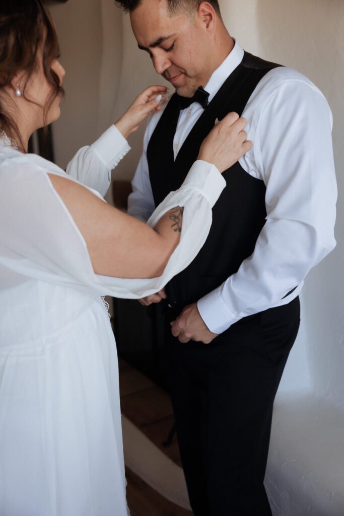 Bride and groom getting ready together in their Joshua Tree Airbnb before their elopement