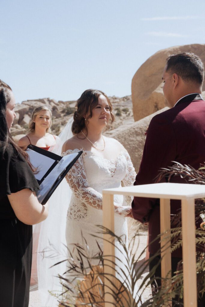 Close-up of bride and groom holding hands during emotional elopement vows