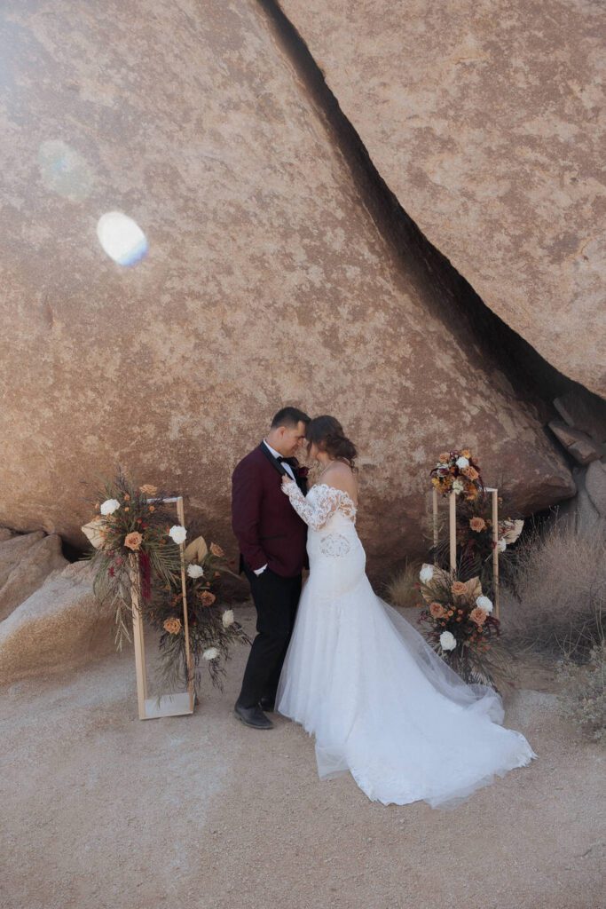 Newlyweds framed by towering Joshua trees during sunset photos