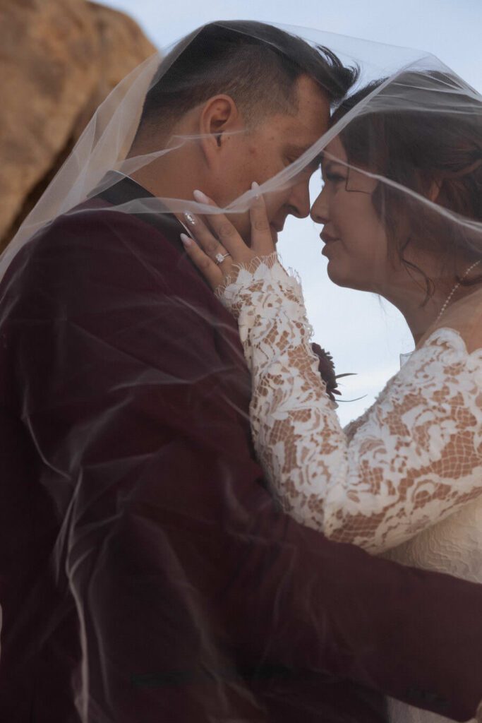 Groom holding bride’s hand as they walk through desert trails after ceremony