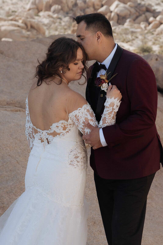 Groom holding bride’s hand as they walk through desert trails after ceremony