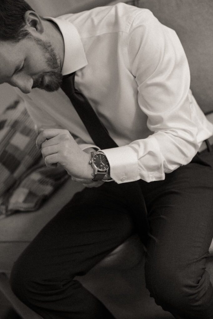 Groom adjusting forest green suit from Caswell’s before ceremony