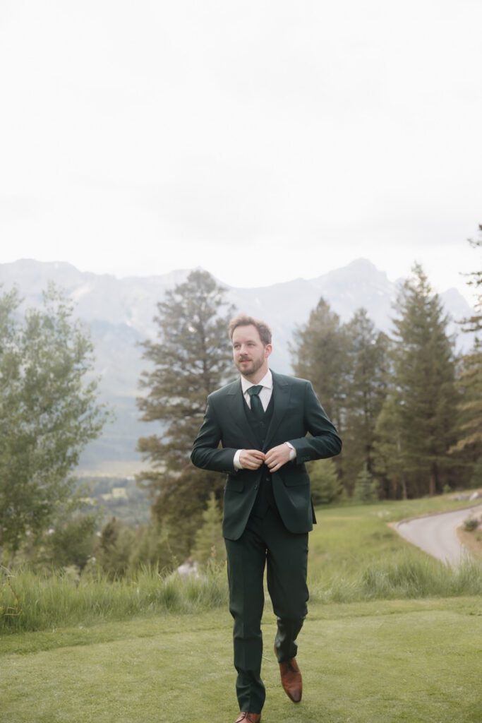 Stylish groom in green suit at a luxury Canmore wedding venue