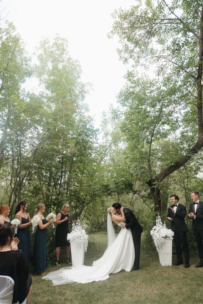 First kiss as newlyweds under a soft cloudy sky in moon lake wedding photography