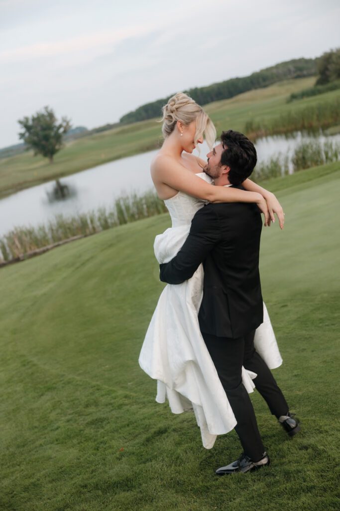 Bride and groom laughing as they run barefoot through the grass in moon lake wedding photography