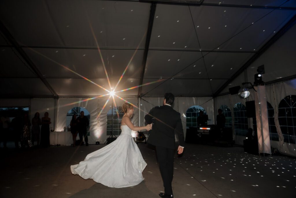 Couple sharing their first dance under string lights in moon lake wedding photography