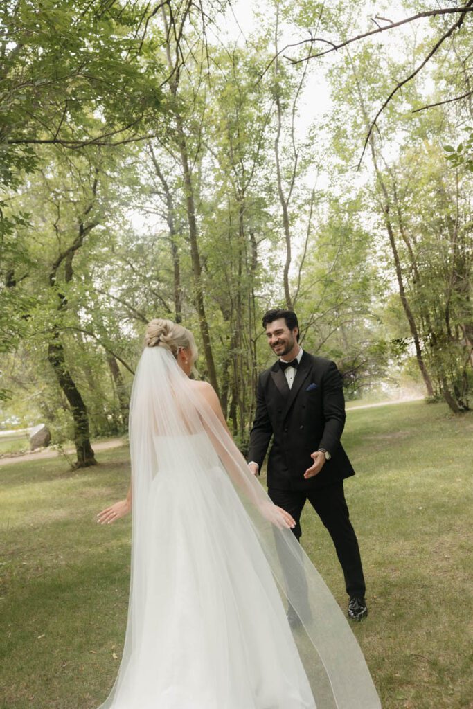 Bride laughing during vow exchange with golden light filtering through trees in moon lake wedding photography