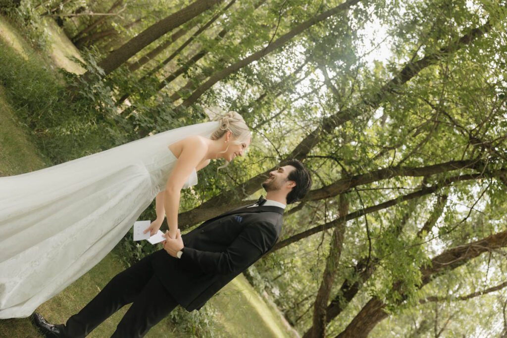 Intimate moment between bride and groom, hands clasped and eyes closed in moon lake wedding photography