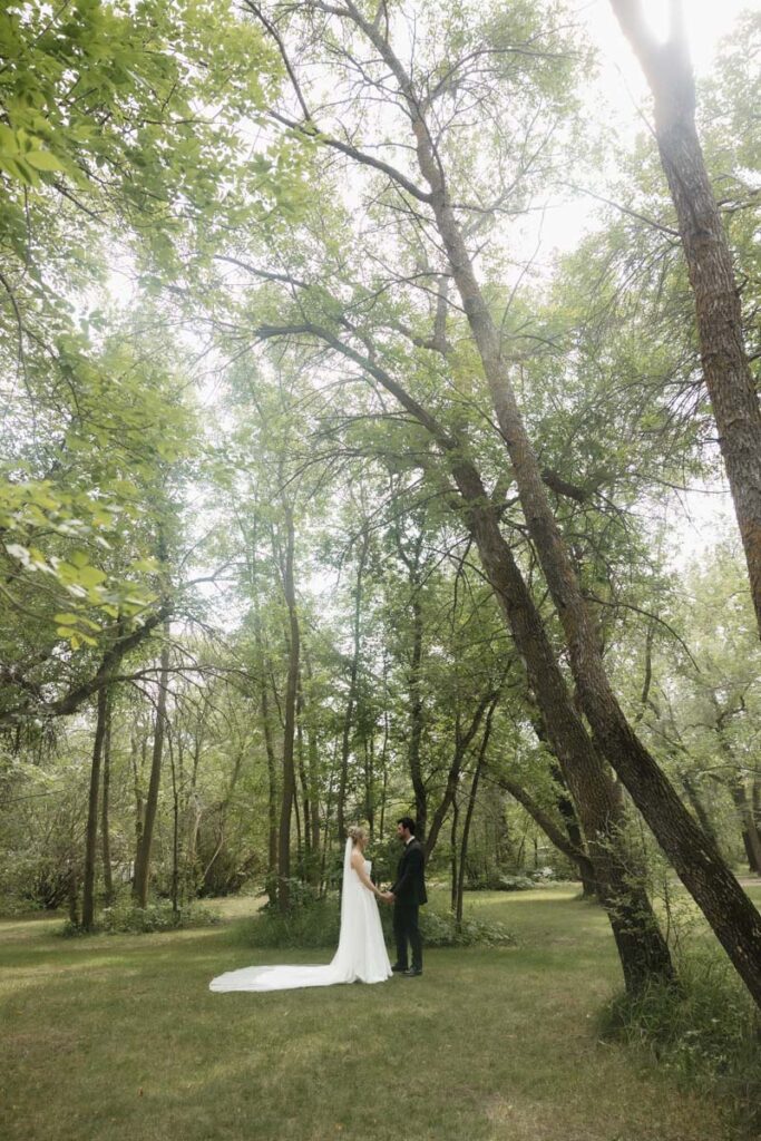 Intimate moment between bride and groom, hands clasped and eyes closed in moon lake wedding photography