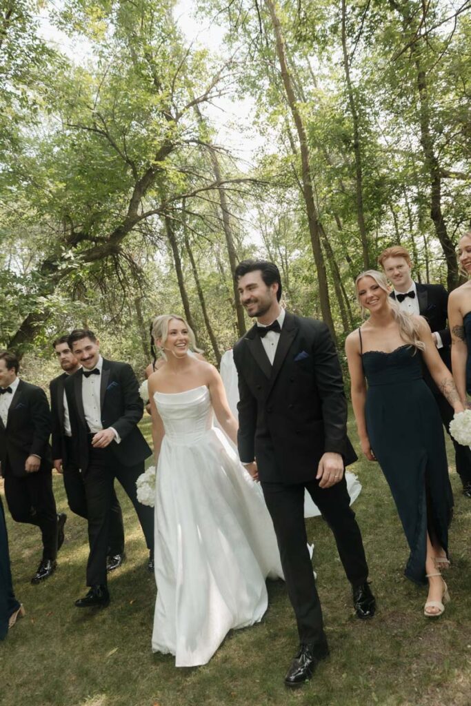 Group portrait of the wedding party walking together, all smiling in moon lake wedding photography