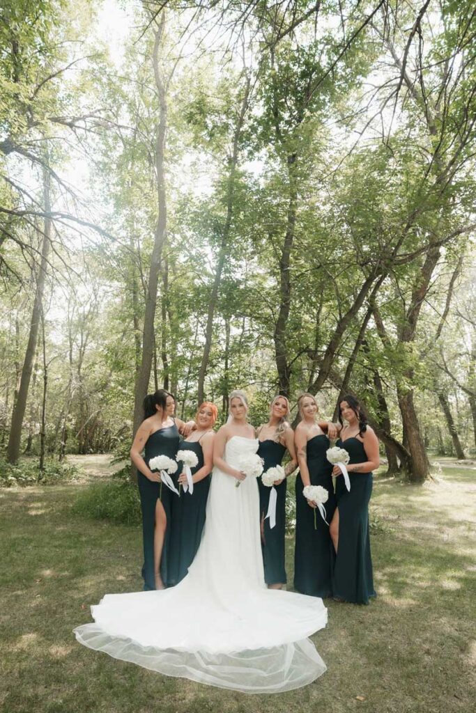 Bridesmaids holding matching neutral-toned bouquets with bride in center in moon lake wedding photography
