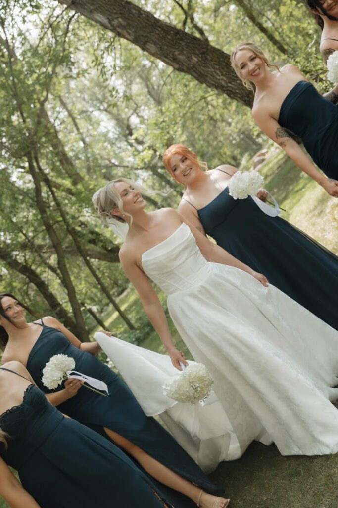 Bridesmaids holding matching neutral-toned bouquets with bride in center in moon lake wedding photography