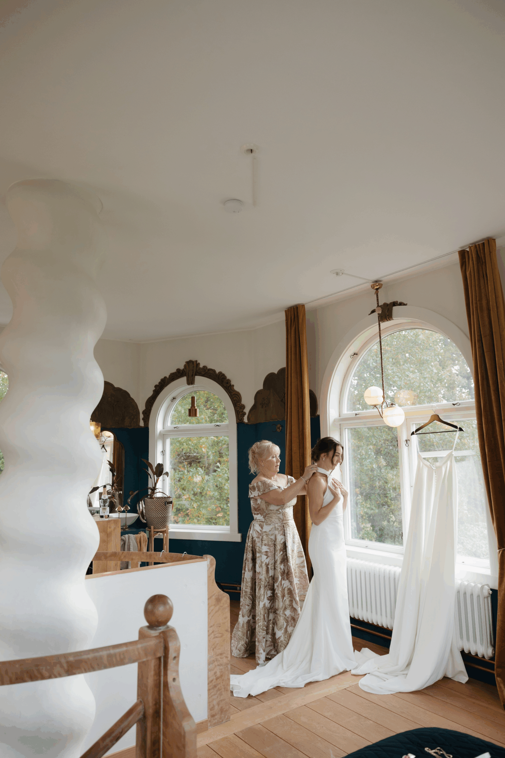 Katie’s mom fastening the back of her wedding gown in a quiet, emotional moment.